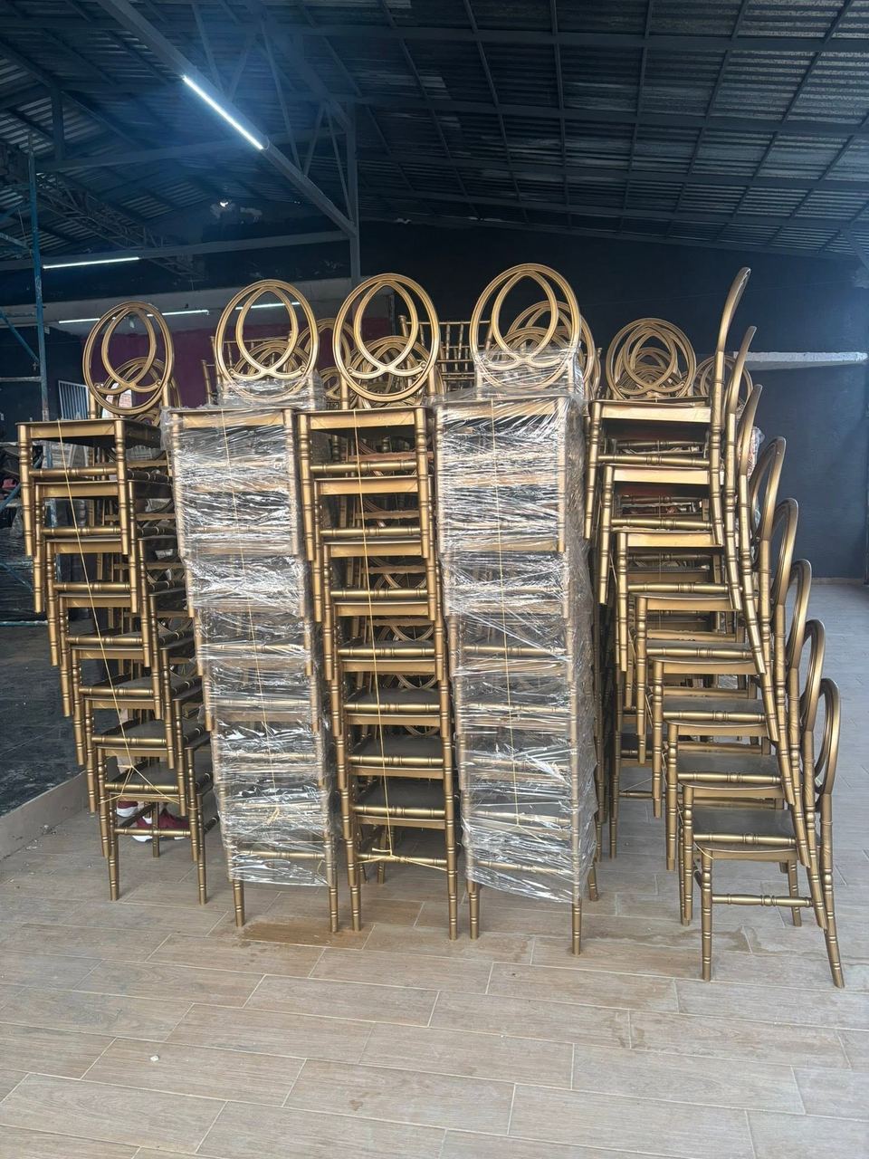 Sillas Phoenix doradas con respaldo circular entrelazado