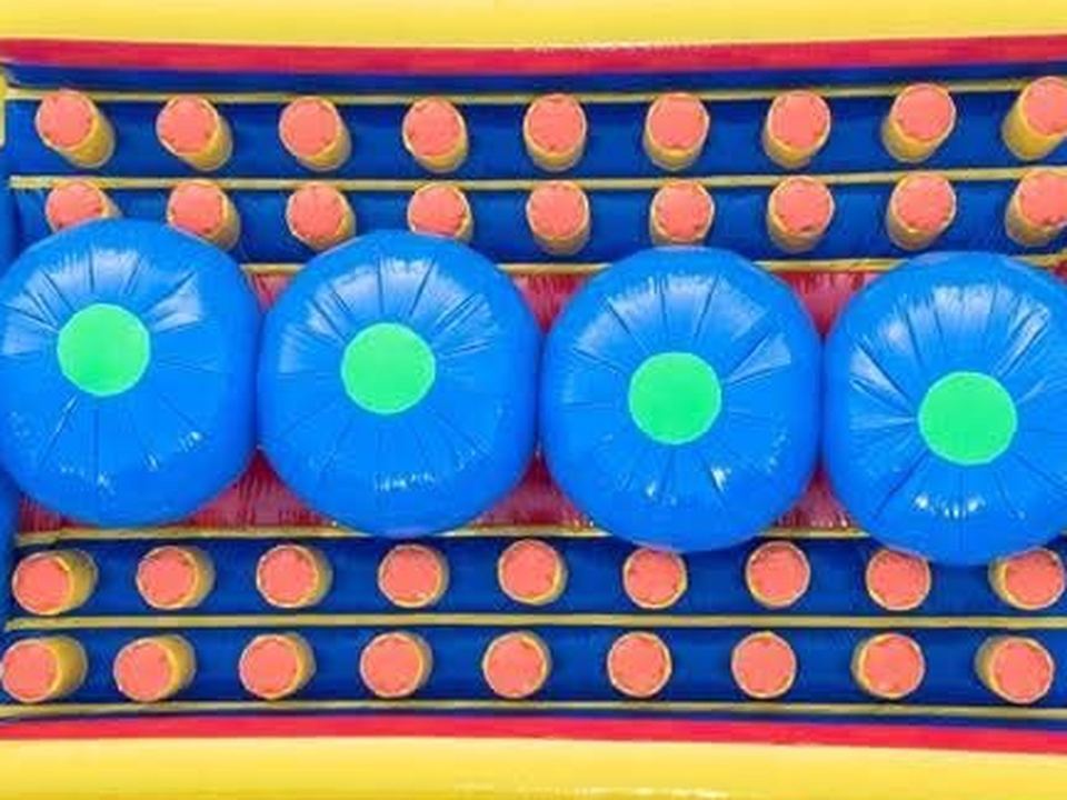 Inflable resbalón con burbujas azules y obstáculos naranjas para recorrido
